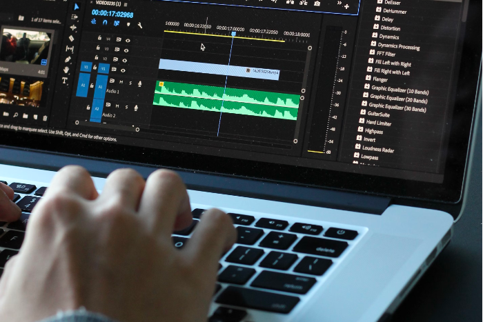 A person edits a video on a laptop using video editing software